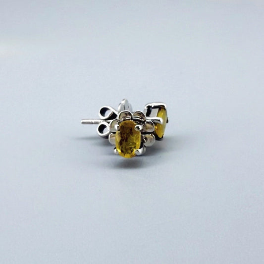 Natural yellow sapphire stud earrings in white gold plated sterling silver with butterfly backs.