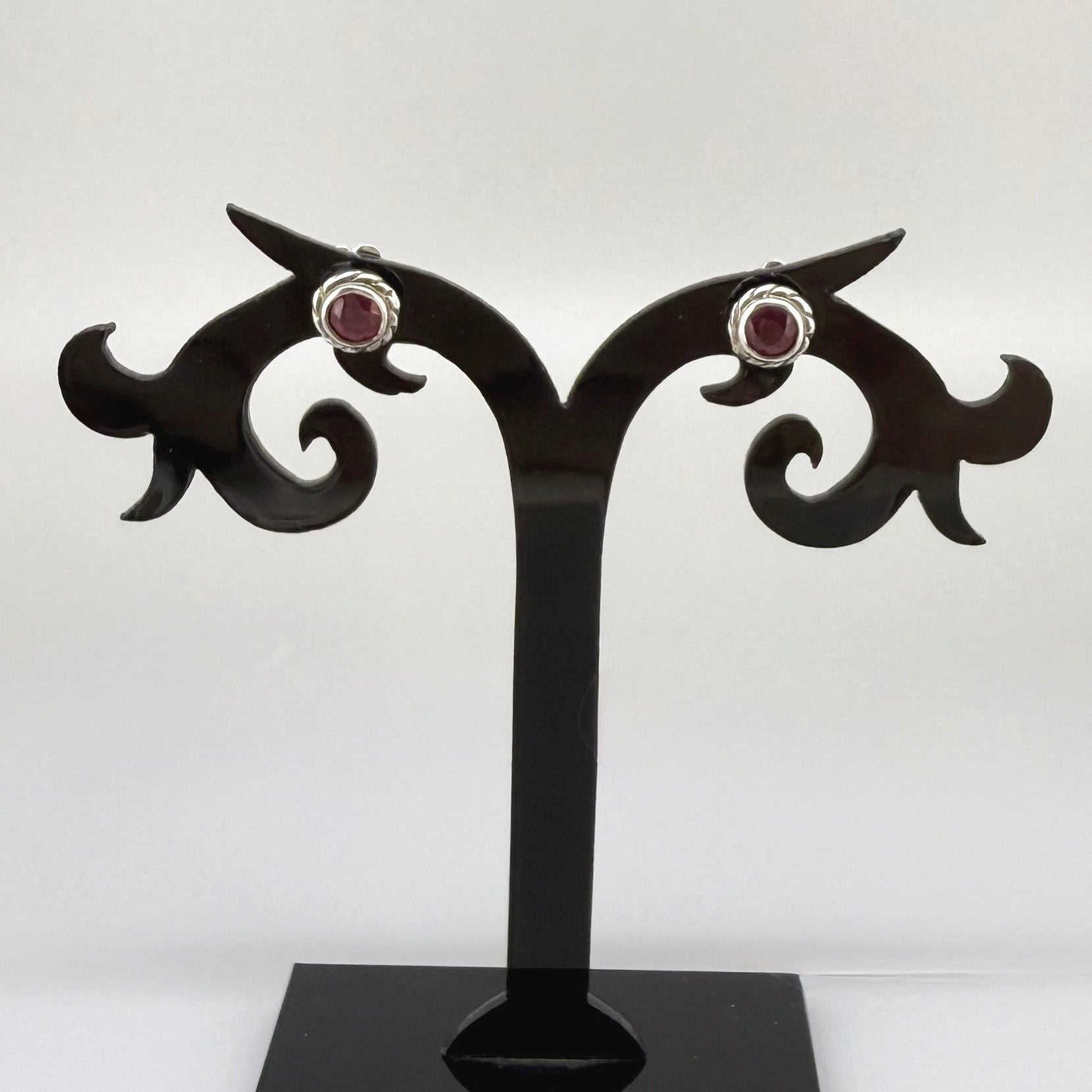 Ruby stud earrings in white gold plated sterling silver with butterfly backs.