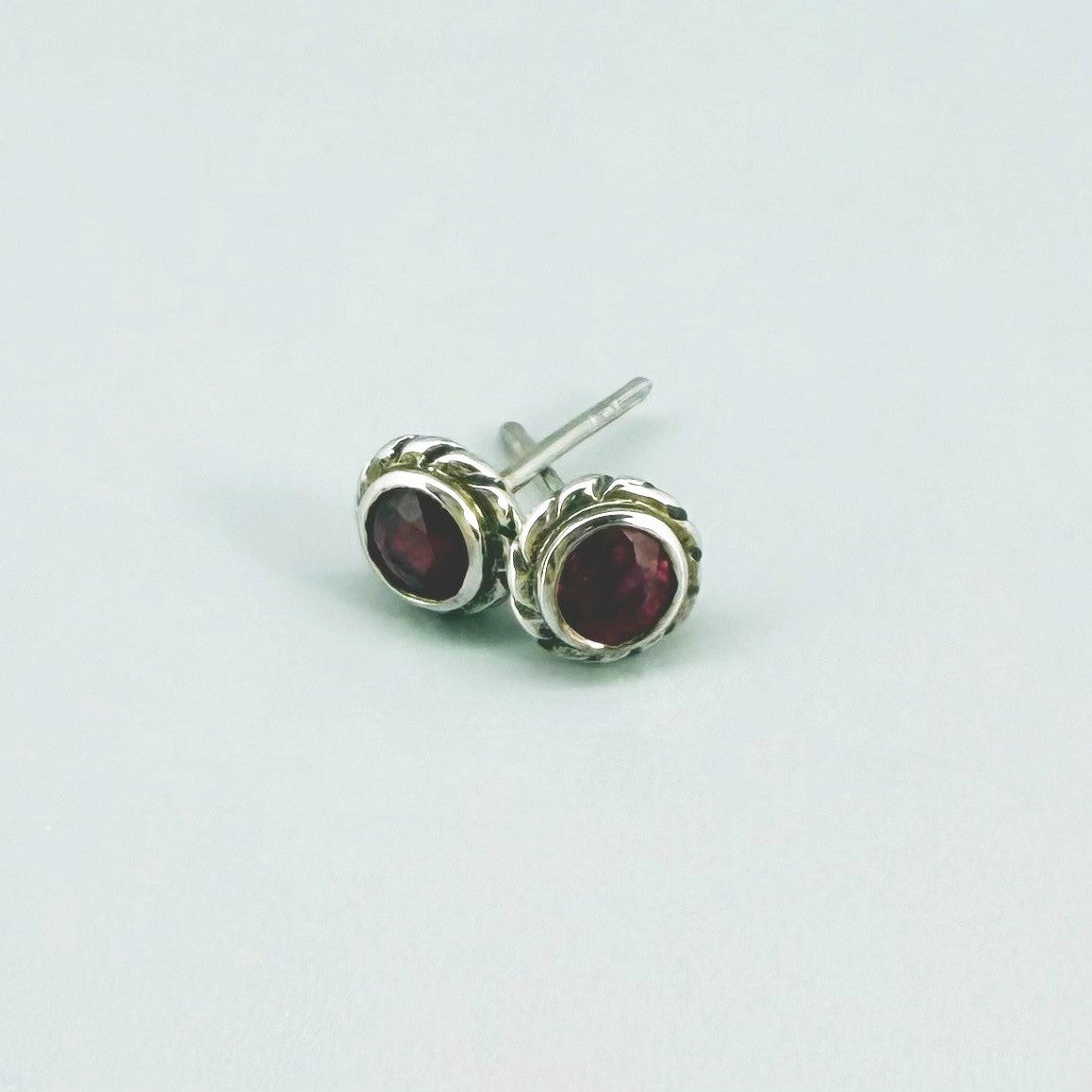 Ruby stud earrings in white gold plated sterling silver with butterfly backs.