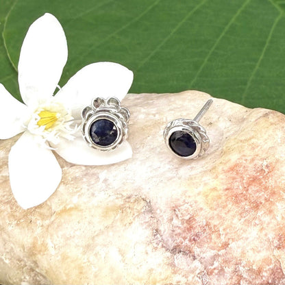 Blue sapphire stud earrings in white gold plated sterling silver with round floral backs.