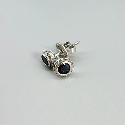Blue sapphire stud earrings in white gold plated sterling silver with round floral backs.