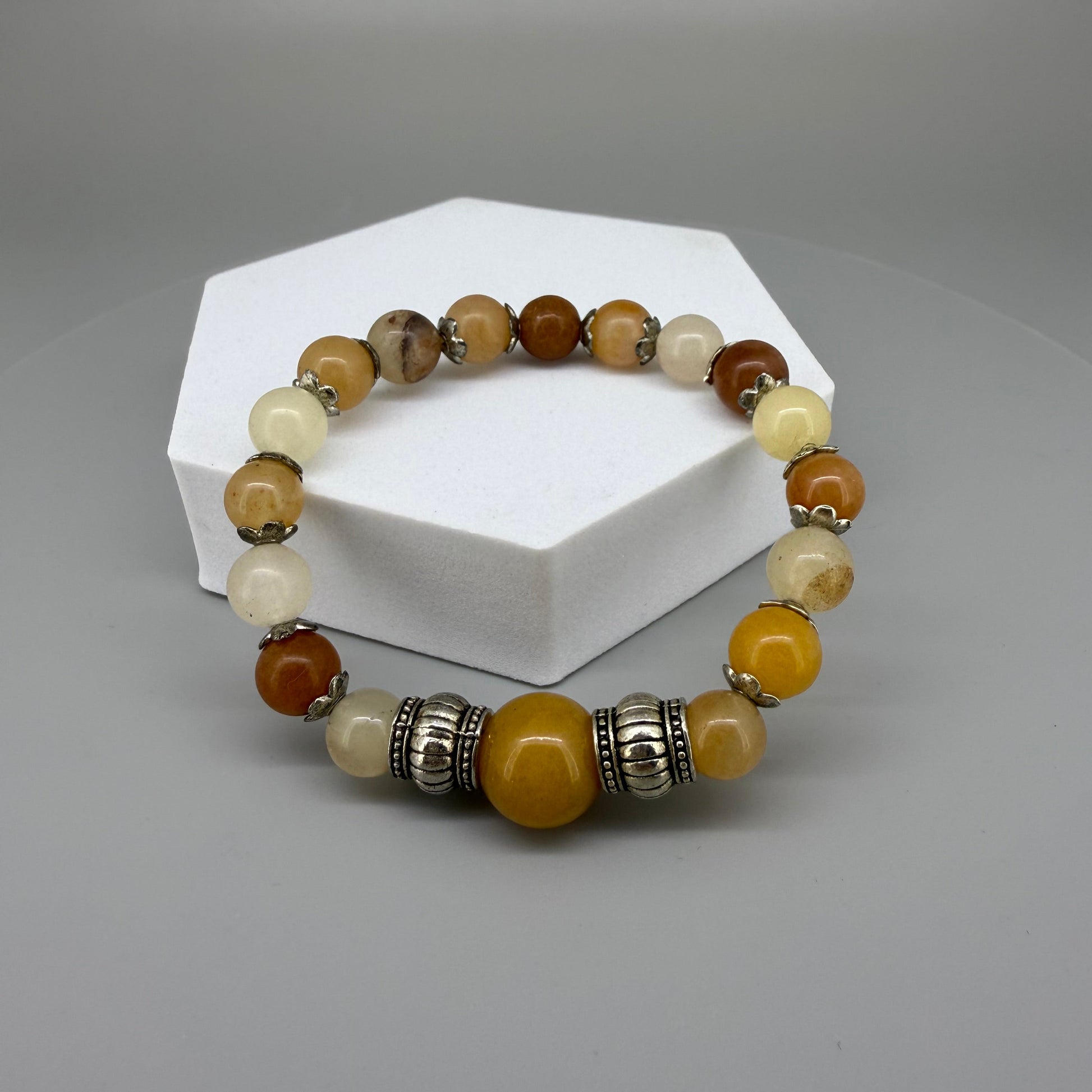 Jade beaded bracelet, 18cm, beige, orange, and brown gemstone beads with larger focal bead and two metal accents on elastic stretch band.