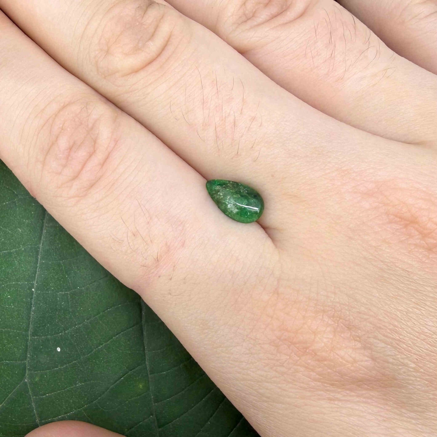 0.9 ct natural untreated emerald from Zambia, one side polished and the other cabochon-shaped.