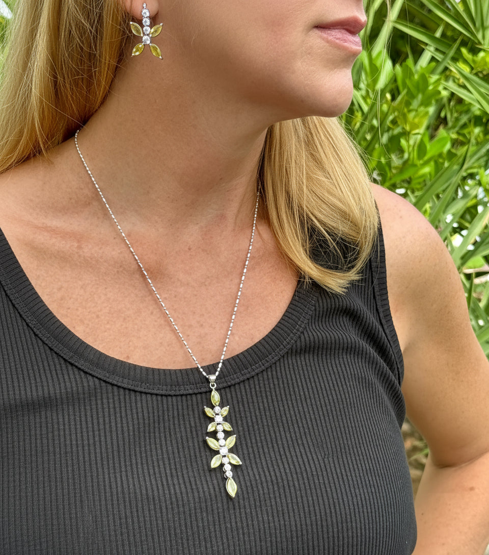 Handcrafted pendant with natural yellow sapphires (7.37 ct) and cubic zirconia in white-gold-plated silver leaf design, shown with matching earrings.
