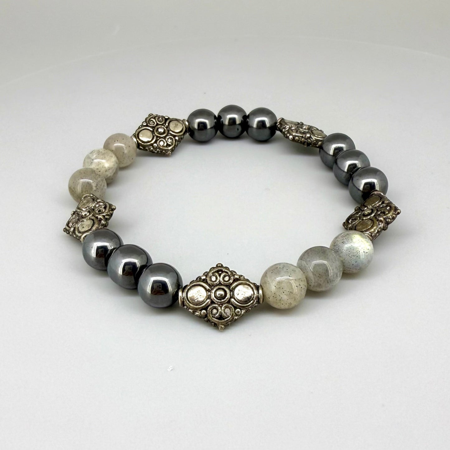 Howlite and hematite beaded bracelet, 18cm, white and metallic grey gemstone beads with carved metal accents on elastic stretch band.
