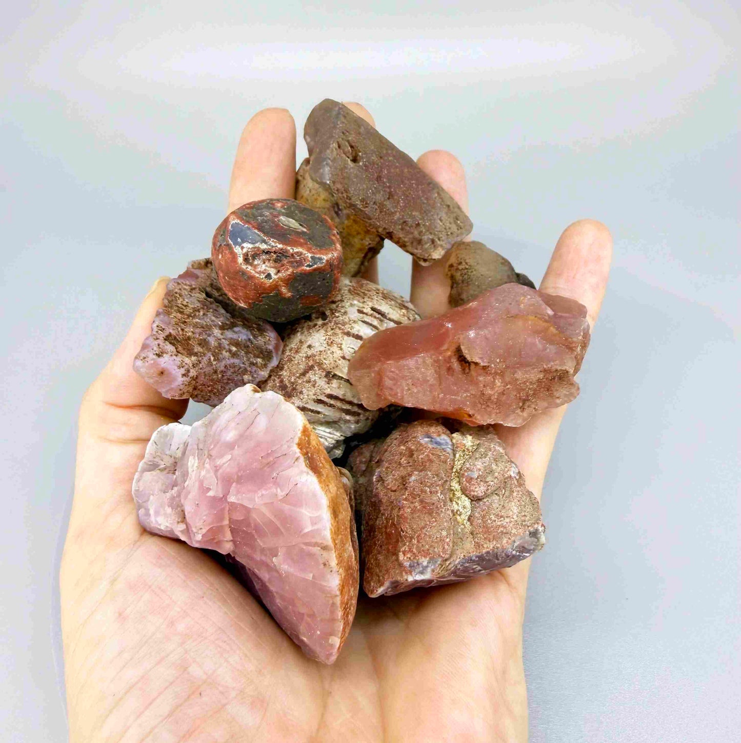 Rough and uncut chalcedony/carnelian lot in natural red-orange tones, untreated raw gemstones.