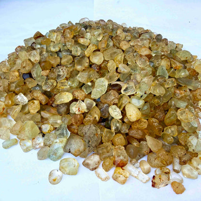 Natural champagne-gold topaz rough with warm golden tones, uncut and untreated, photographed on neutral background.