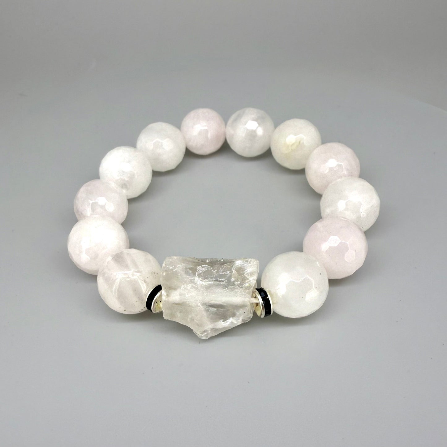 Rose quartz beaded bracelet, 18cm, light pink gemstone beads with larger clear accent stone on elastic stretch band.