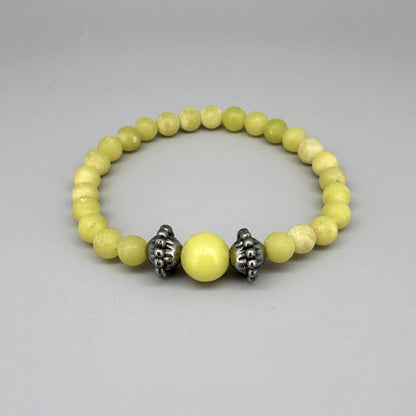 Yellow jasper beaded bracelet, 18cm, vibrant gemstone beads with larger focal bead framed by carved metal accents on elastic stretch band.