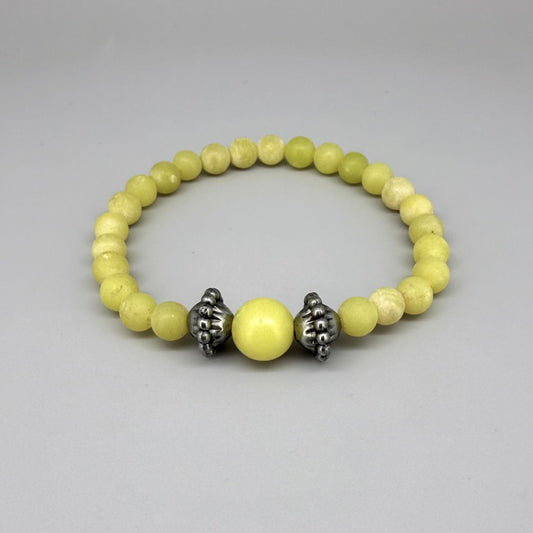 Yellow jasper beaded bracelet, 18cm, vibrant gemstone beads with larger focal bead framed by carved metal accents on elastic stretch band.