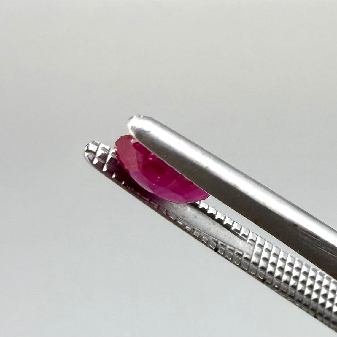 0.6 ct natural Songea ruby, oval cut in a pink-red tone.