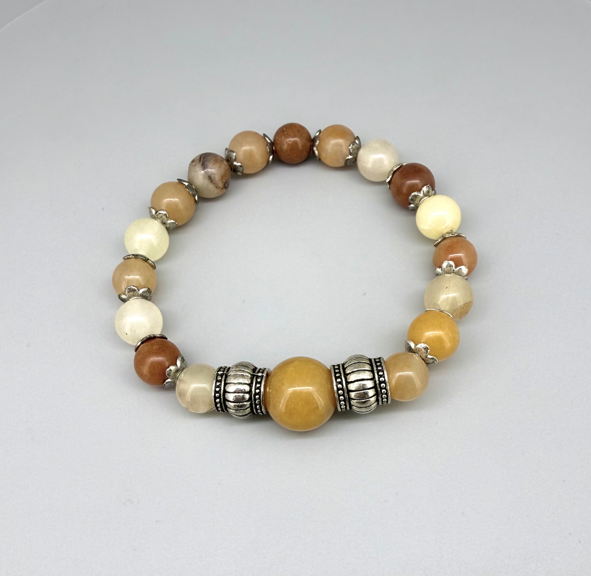 Jade beaded bracelet, 18cm, beige, orange, and brown gemstone beads with larger focal bead and two metal accents on elastic stretch band.