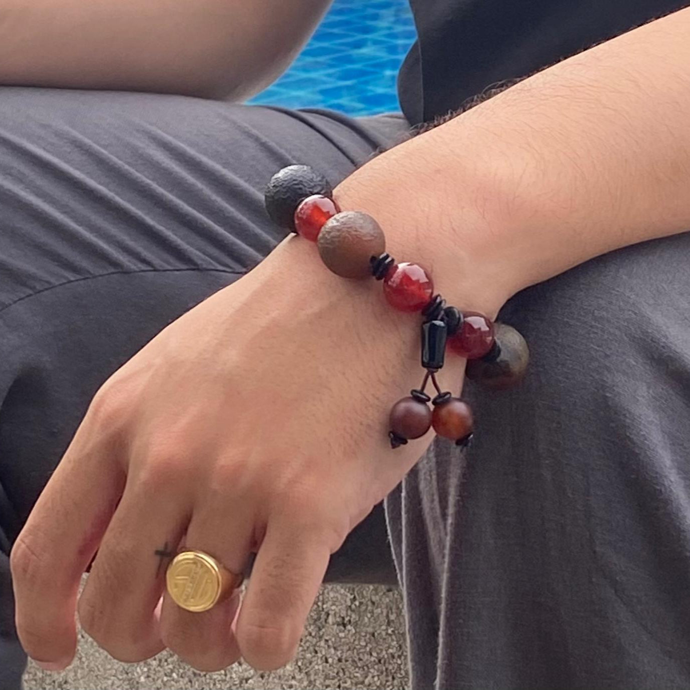Carnelian and agate beaded bracelet, 20cm, red-orange gemstone beads with large black square bead on elastic stretch band.