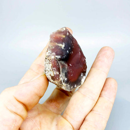 Chalcedony rough stone with orange-red carnelian core and darker translucent zones, natural quartz specimen.