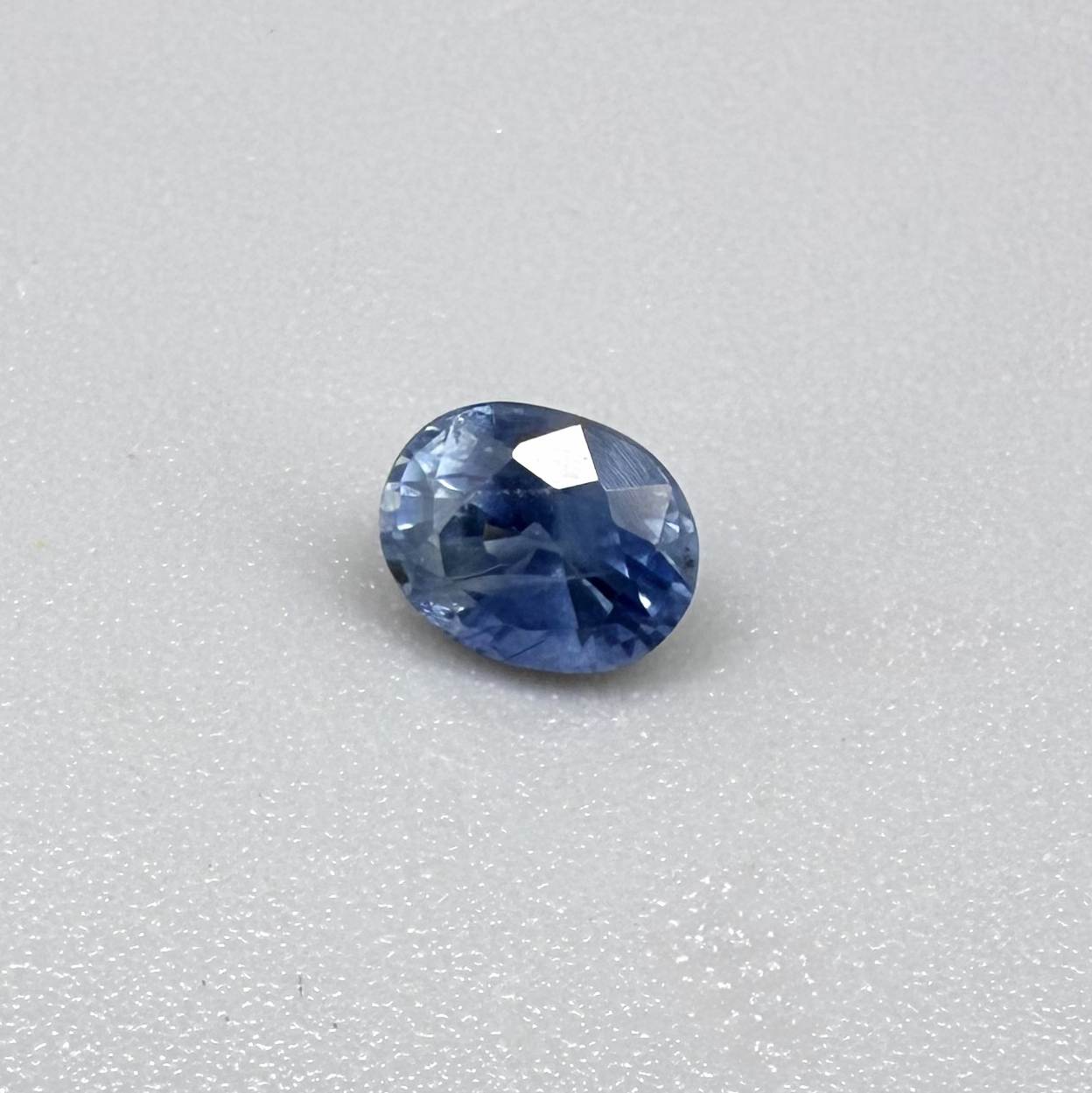 Soft medium blue sapphire in oval cut with natural silky texture and gentle blue color tone.