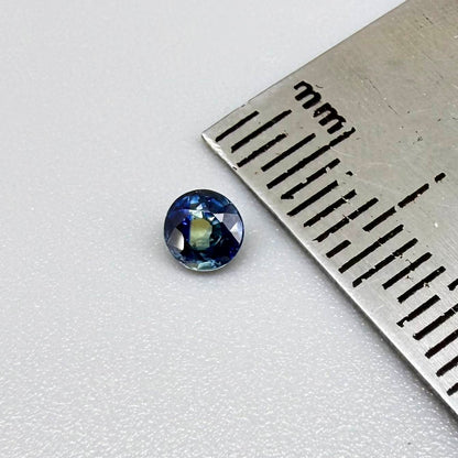 Round-cut bright blue sapphire from Bangkaja, Thailand showing subtle yellow undertone and natural color zoning.