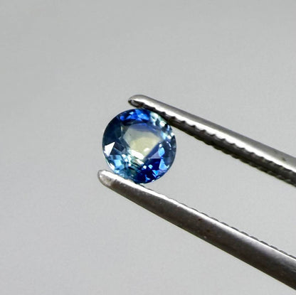 Round-cut bright blue sapphire from Bangkaja, Thailand showing subtle yellow undertone and natural color zoning.