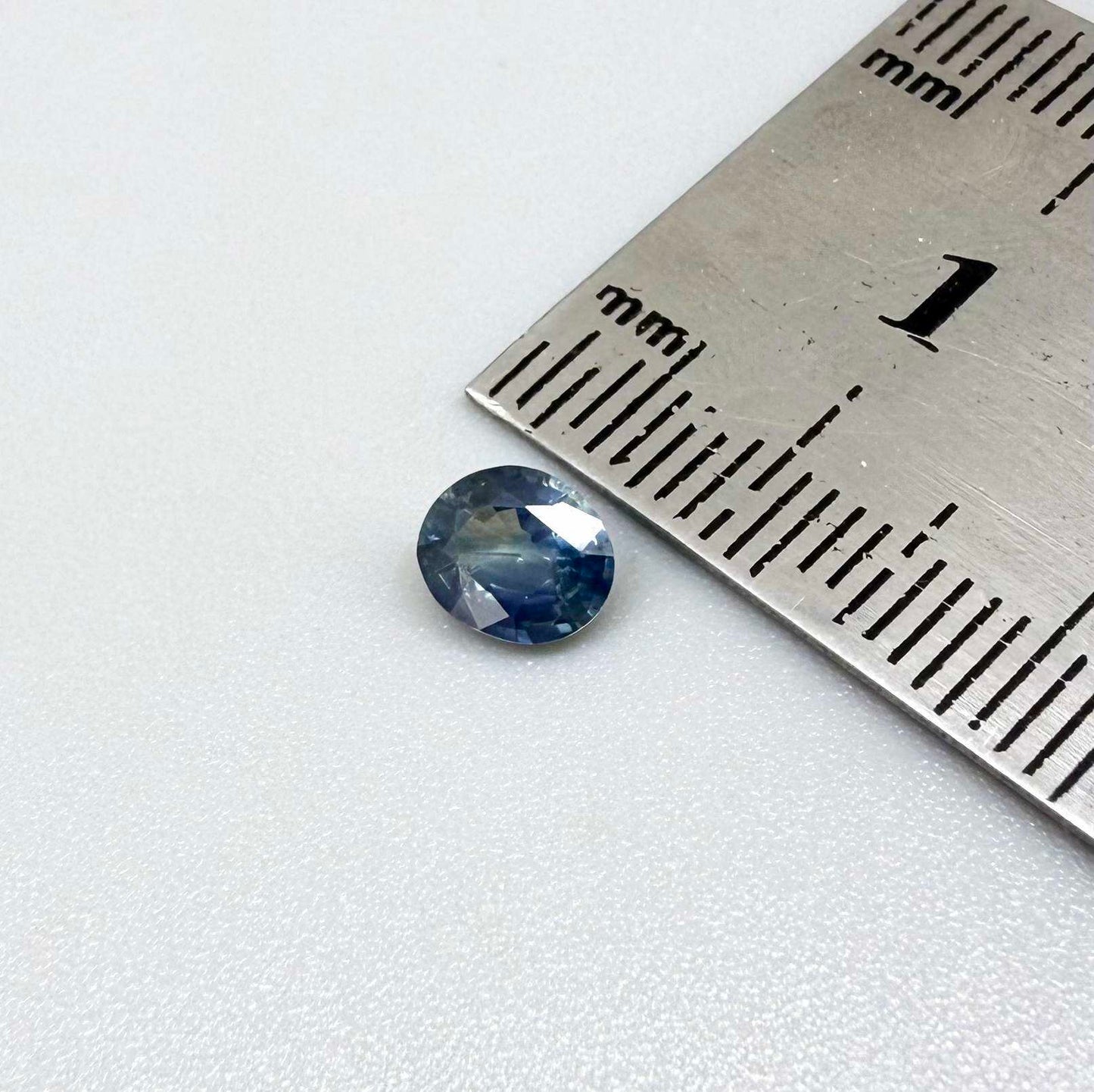 Oval cut light medium blue sapphire from Bangkaja, Thailand with natural color zoning and faceted brilliance.