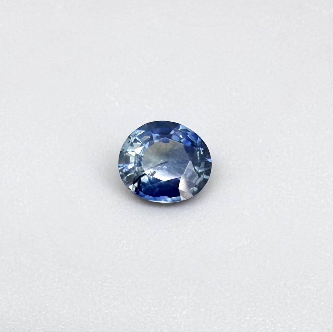Oval cut light medium blue sapphire from Bangkaja, Thailand with natural color zoning and faceted brilliance.
