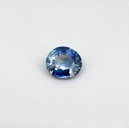 Oval cut light medium blue sapphire from Bangkaja, Thailand with natural color zoning and faceted brilliance.