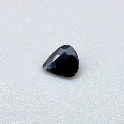 Trillion-cut dark teal blue sapphire from Bangkaja, Thailand, natural faceted gemstone with deep blue-green undertones.