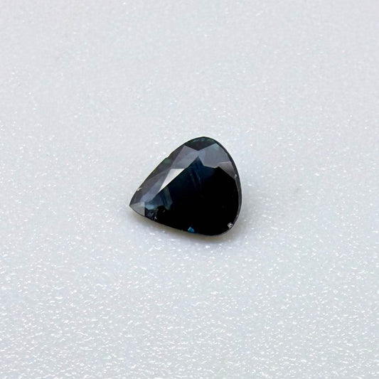 Trillion-cut dark teal blue sapphire from Bangkaja, Thailand, natural faceted gemstone with deep blue-green undertones.