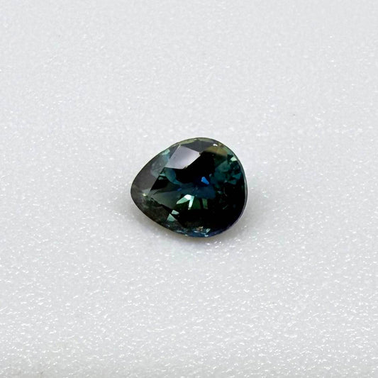 Pear-cut deep teal sapphire from Bangkaja, Thailand with blue-green tones, natural faceted gemstone.