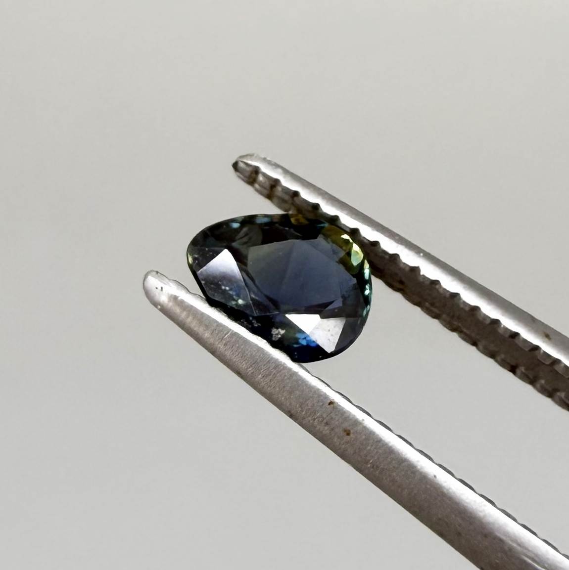 Pear-cut deep teal sapphire from Bangkaja, Thailand with blue-green tones, natural faceted gemstone.