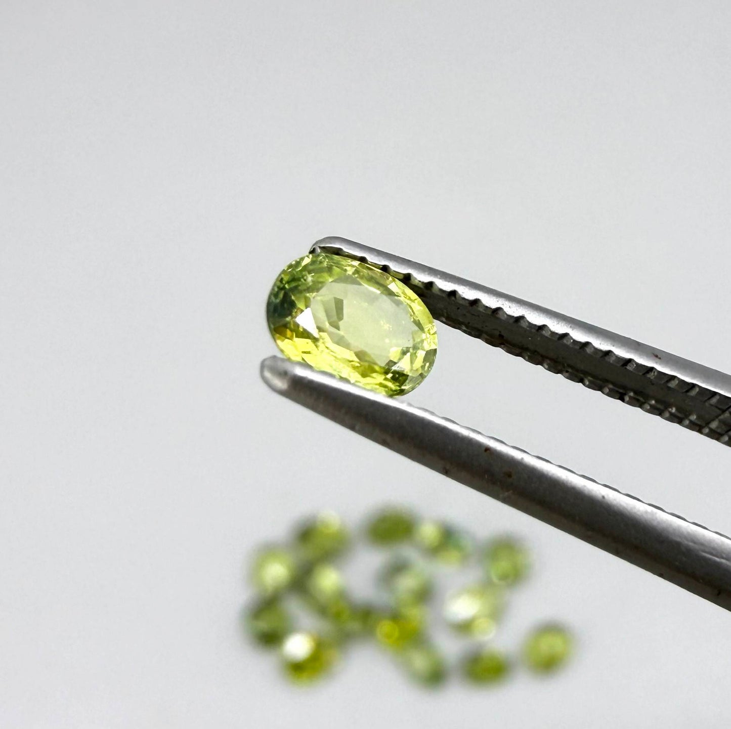 Small parcel of lime green sapphires from Bangkaja, Thailand in oval mixed cuts, natural faceted gemstones.