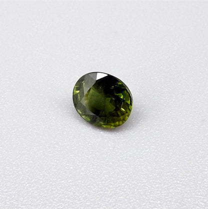 Oval-cut vivid yellowish-green sapphire from Bangkaja, Thailand, natural faceted gemstone with bright lime green tones.