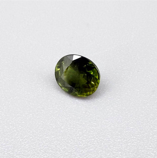 Oval-cut vivid yellowish-green sapphire from Bangkaja, Thailand, natural faceted gemstone with bright lime green tones.