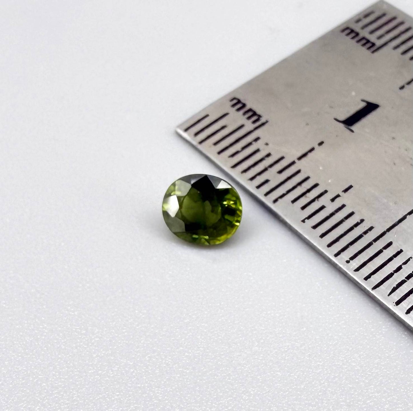 Oval-cut vivid yellowish-green sapphire from Bangkaja, Thailand, natural faceted gemstone with bright lime green tones.