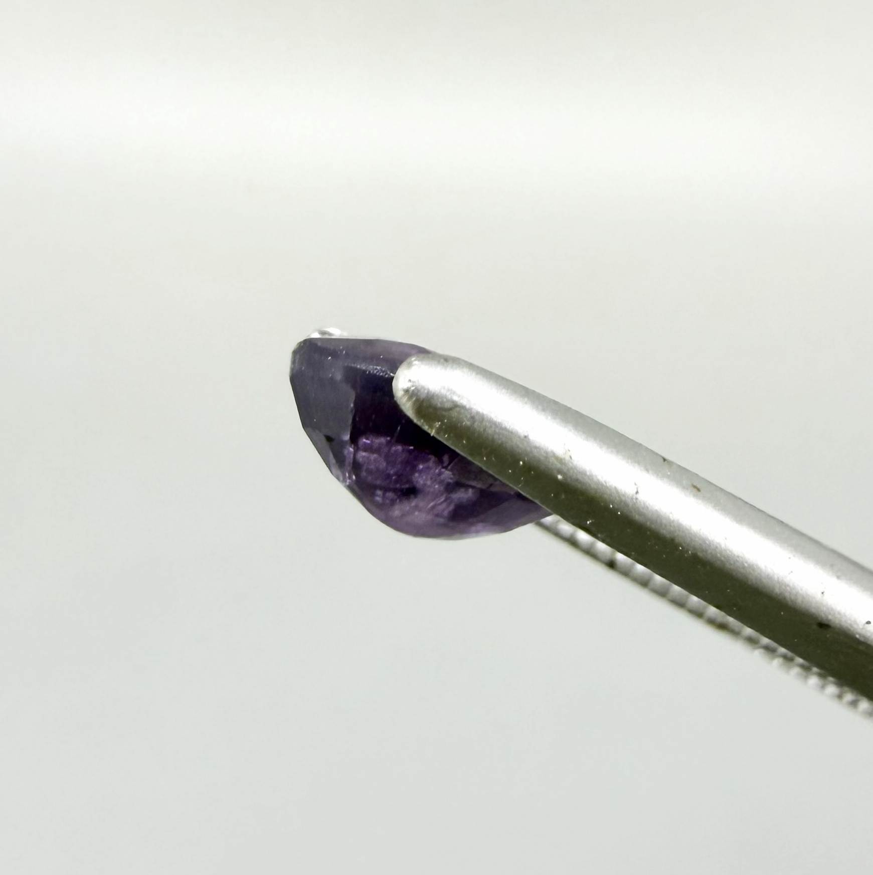 Oval-cut rich purple sapphire from Thailand, natural faceted gemstone suitable for fine jewelry.