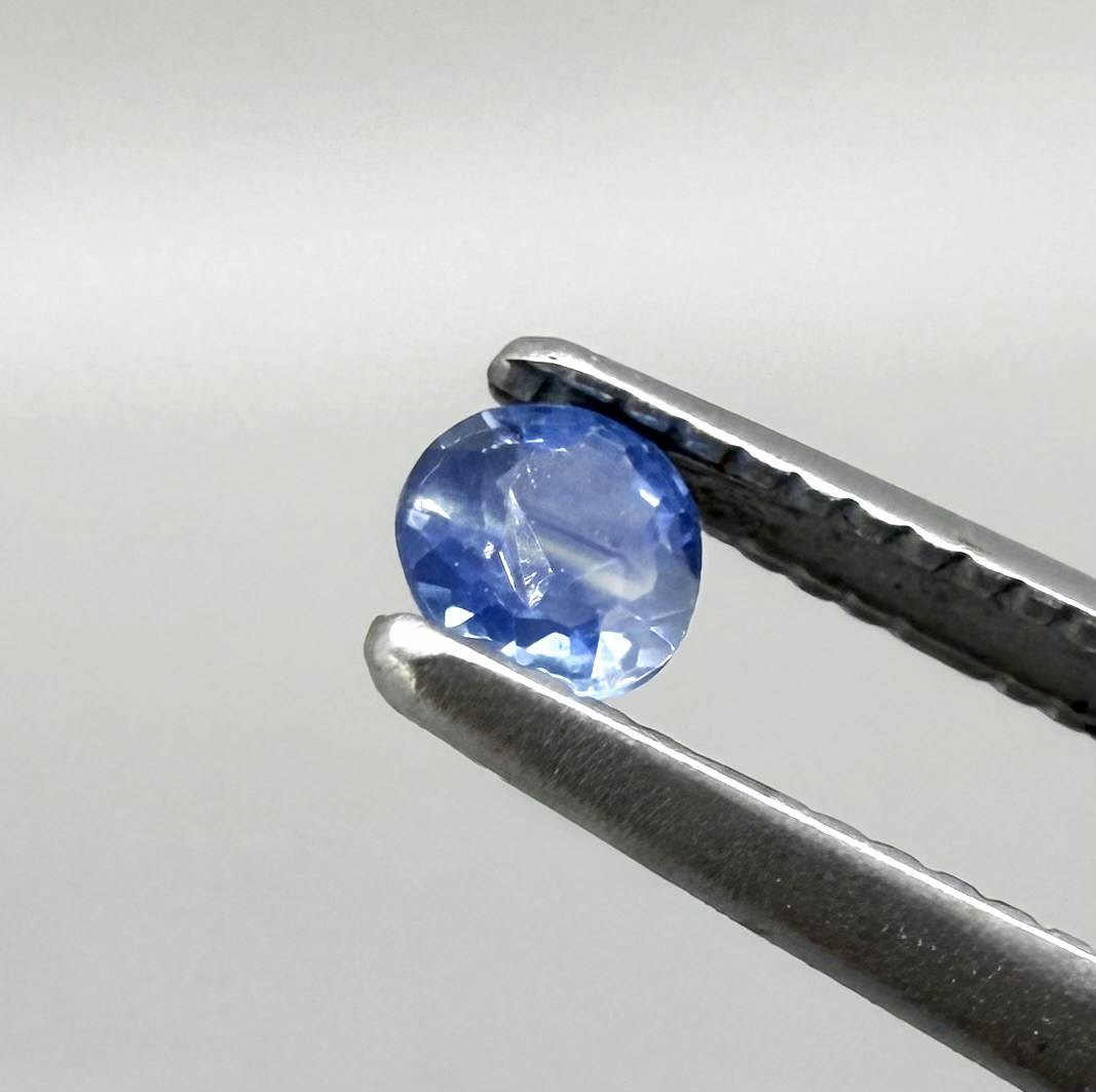 Round soft medium blue sapphire from Bangkaja, Thailand with natural color zoning and gentle silky blue tone.