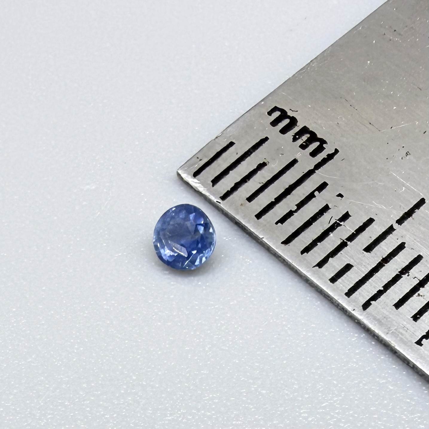 Round soft medium blue sapphire from Bangkaja, Thailand with natural color zoning and gentle silky blue tone.