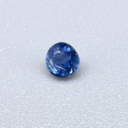 Round soft medium blue sapphire from Bangkaja, Thailand with natural color zoning and gentle silky blue tone.