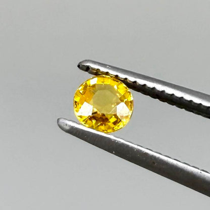 Round warm golden yellow sapphire from Bangkaja, Thailand with slight orange undertone and bright brilliance.