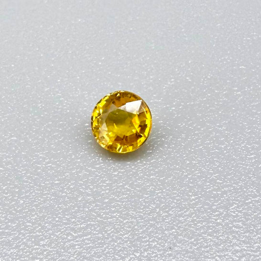 Round warm golden yellow sapphire from Bangkaja, Thailand with slight orange undertone and bright brilliance.