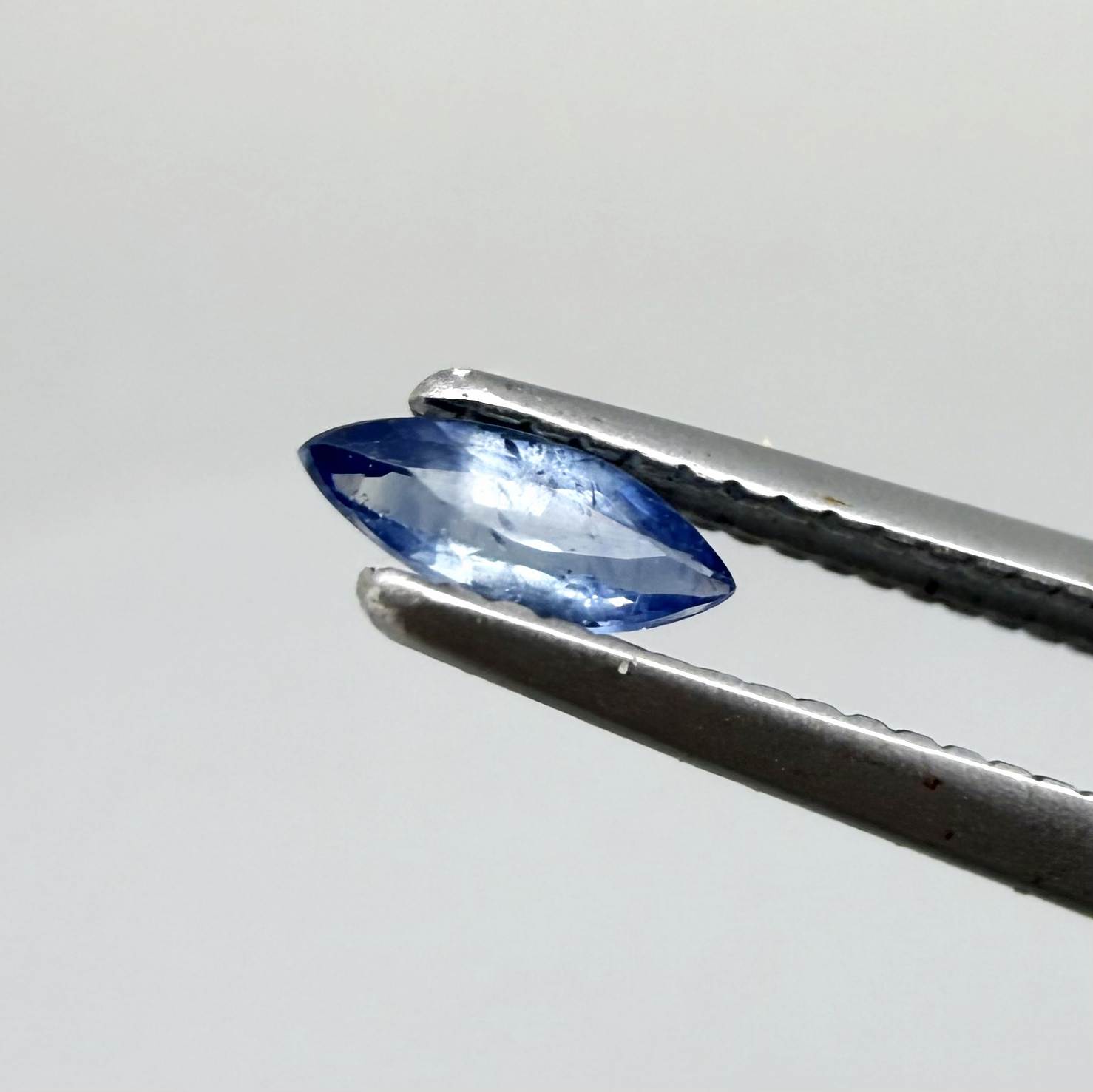 Marquise dark steel blue sapphire from Bangkaja, Thailand with natural zoning and deep blue tone.