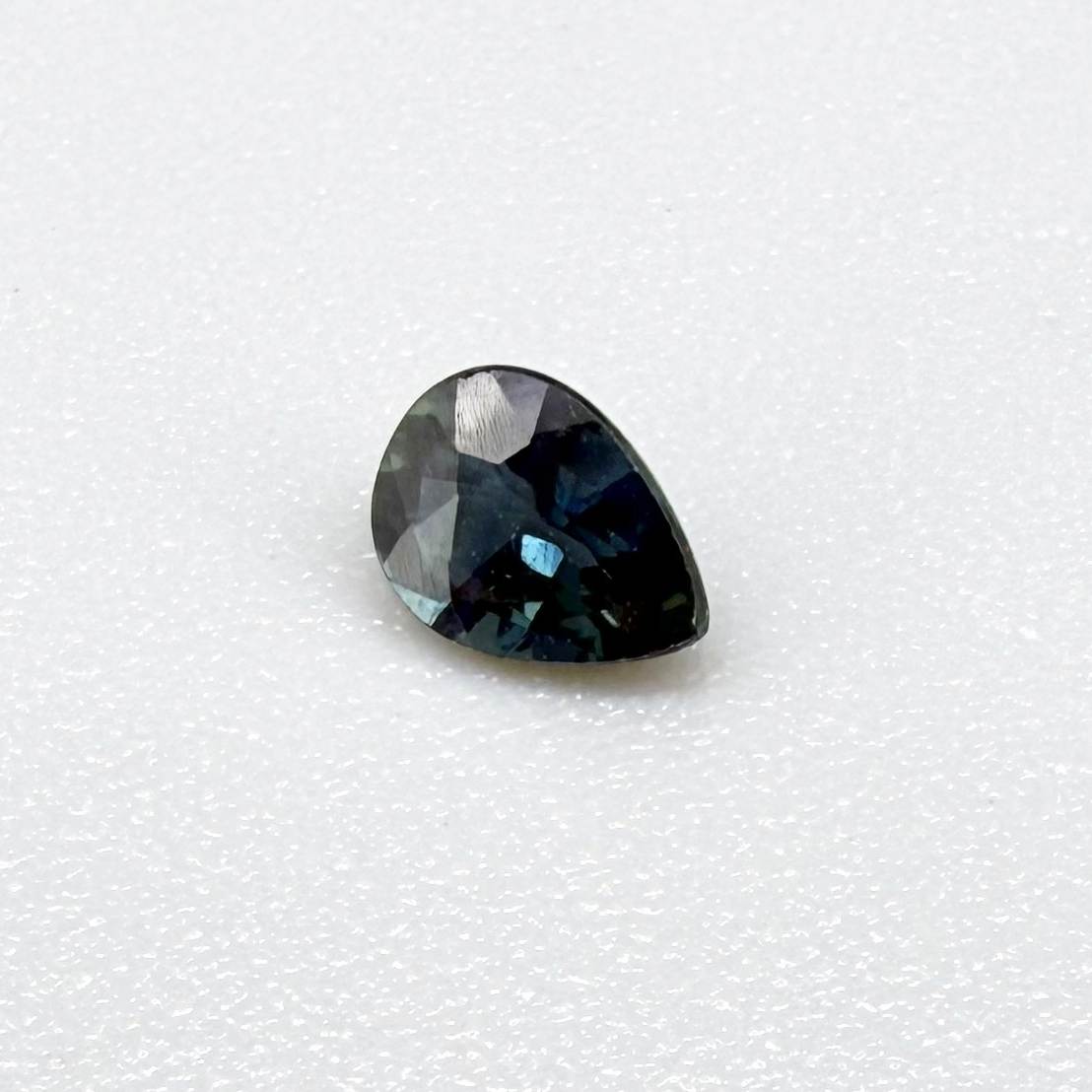 Dark teal blue sapphire from Bangkaja, Thailand in pear cut with deep tone and subtle greenish blue undertone.
