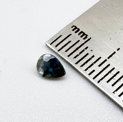 Dark teal blue sapphire from Bangkaja, Thailand in pear cut with deep tone and subtle greenish blue undertone.