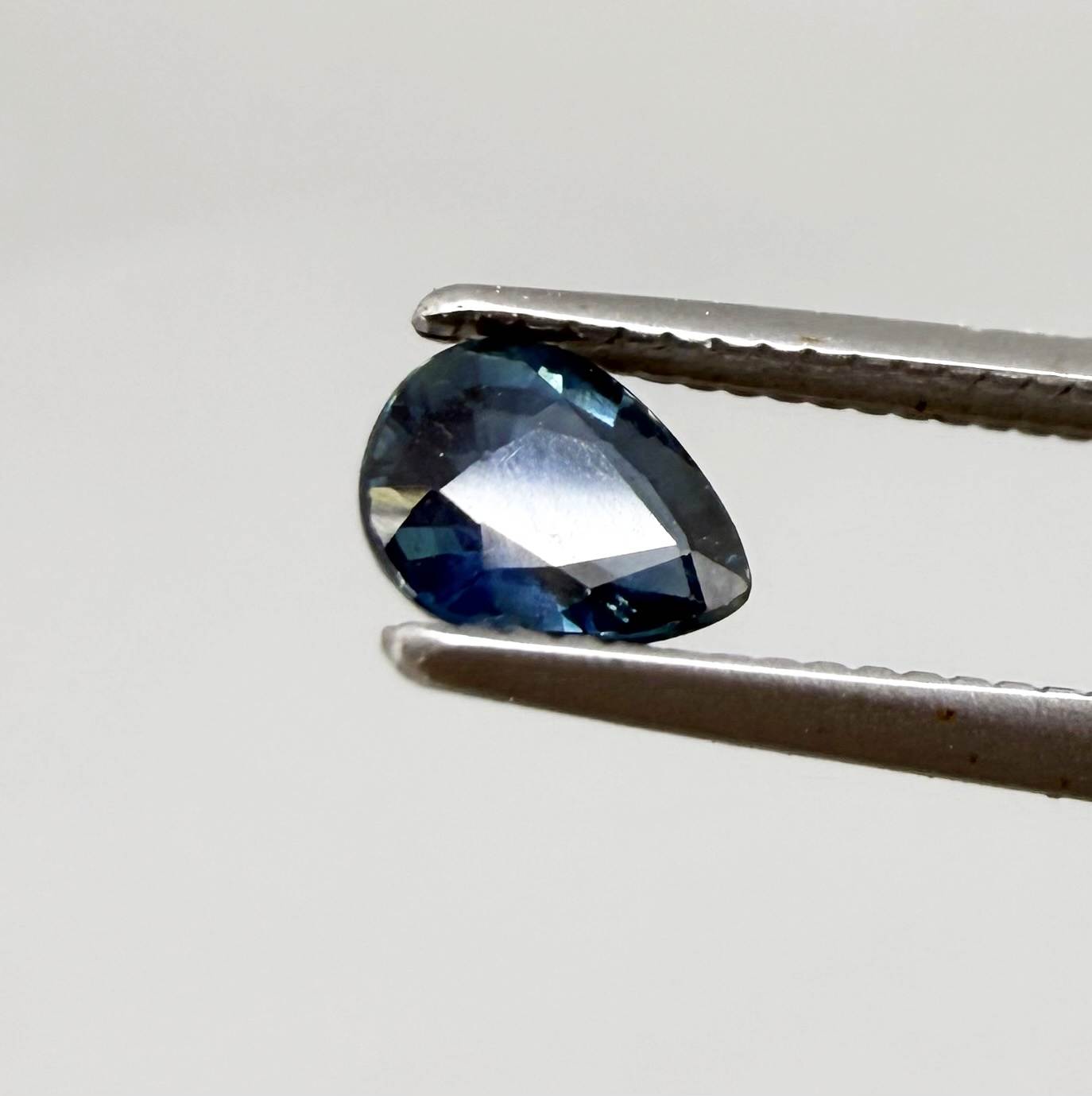 Dark teal blue sapphire from Bangkaja, Thailand in pear cut with deep tone and subtle greenish blue undertone.