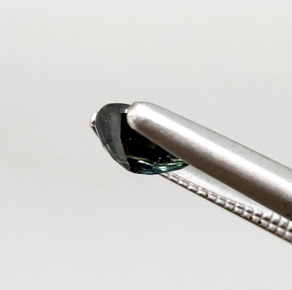 Dark teal blue sapphire from Bangkaja, Thailand in pear cut with deep tone and subtle greenish blue undertone.