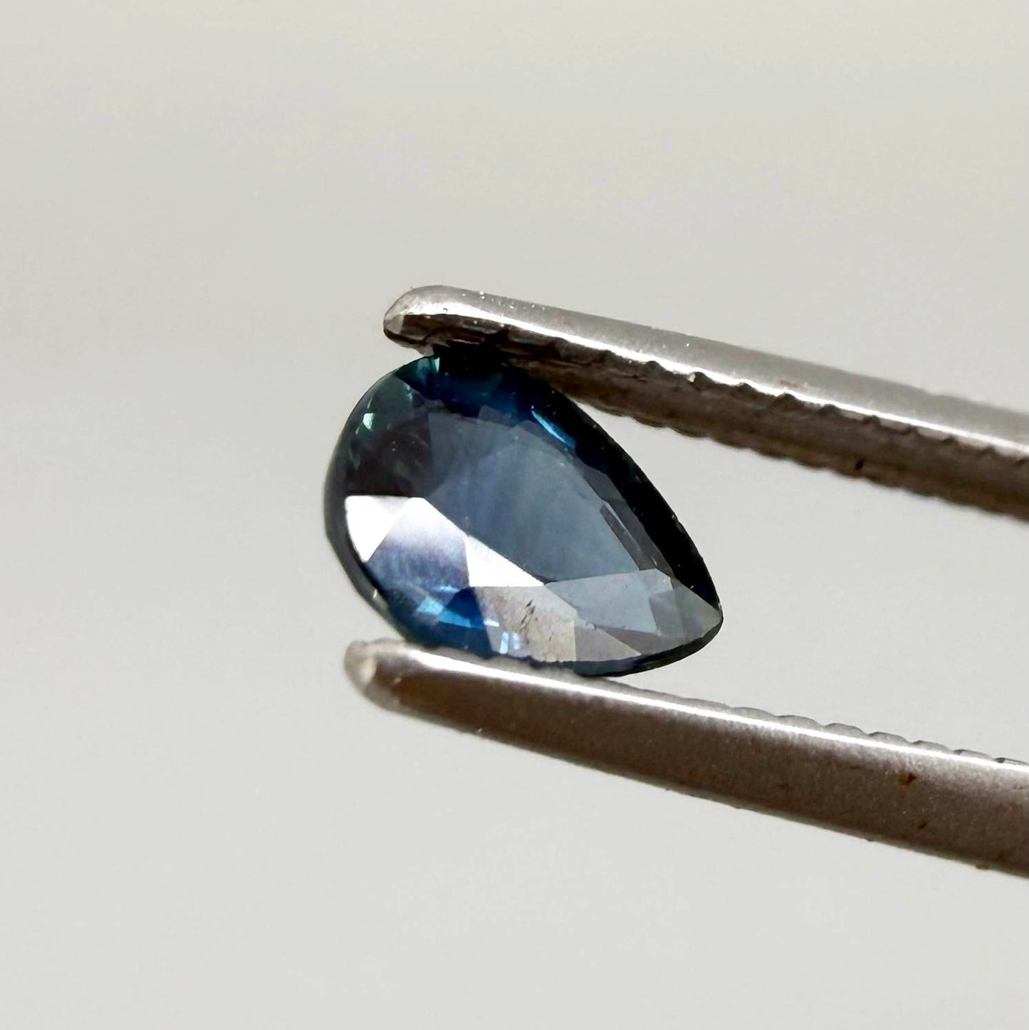 Dark teal blue sapphire from Bangkaja, Thailand in pear cut with deep tone and subtle greenish blue undertone.