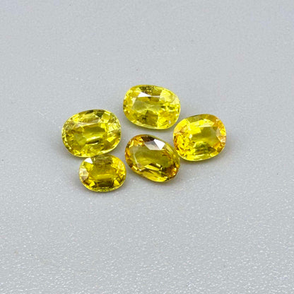 Yellow sapphire parcel in oval cuts from Bangkaja, Thailand showing lemon, golden and orangey tones with bright natural brilliance.