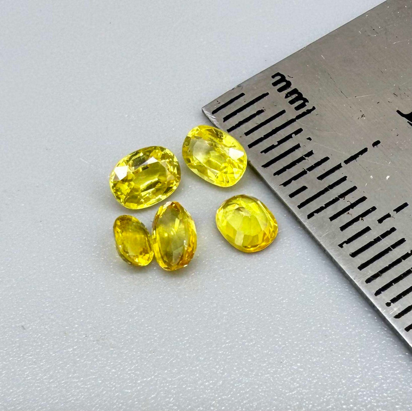 Yellow sapphire parcel in oval cuts from Bangkaja, Thailand showing lemon, golden and orangey tones with bright natural brilliance.