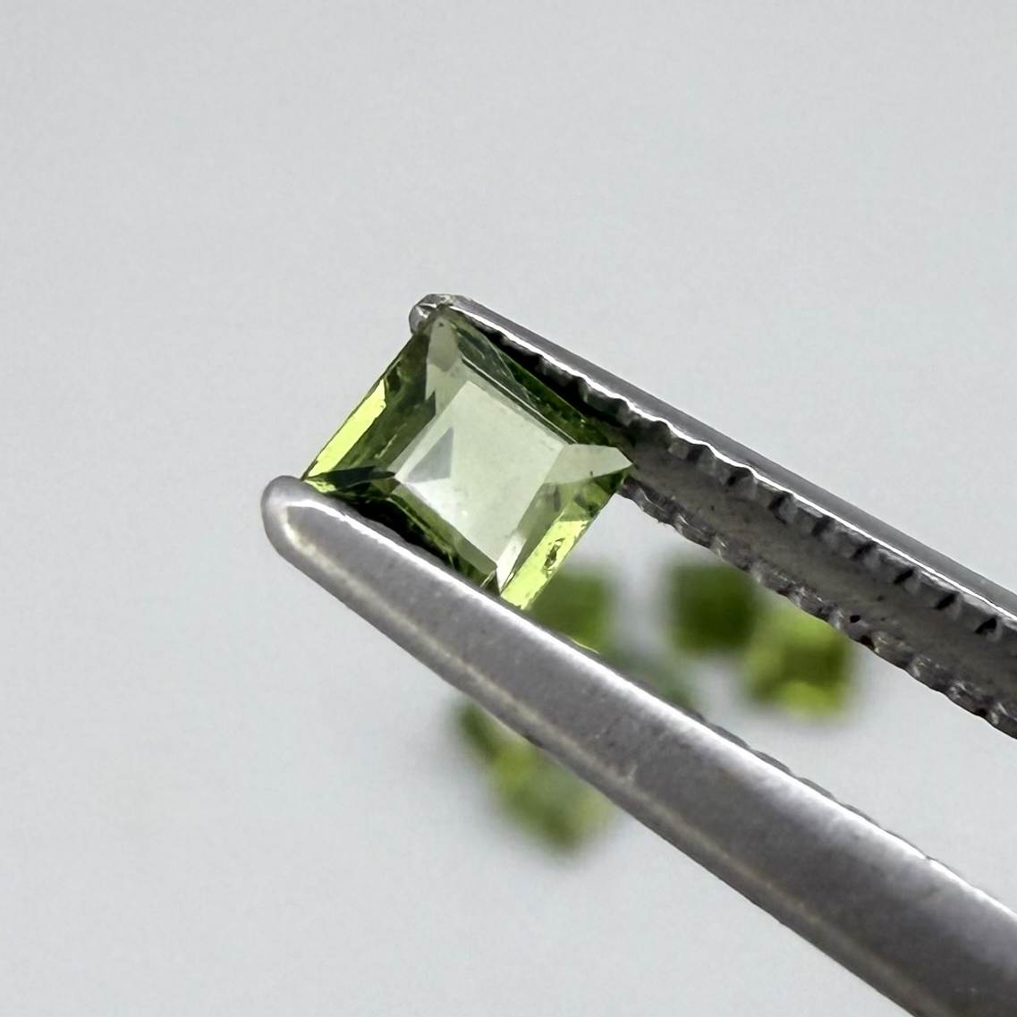 Green sapphire parcel in square cuts from Bangkaja, Thailand showing olive to yellowish-green tones with natural brilliance.