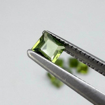Green sapphire parcel in square cuts from Bangkaja, Thailand showing olive to yellowish-green tones with natural brilliance.