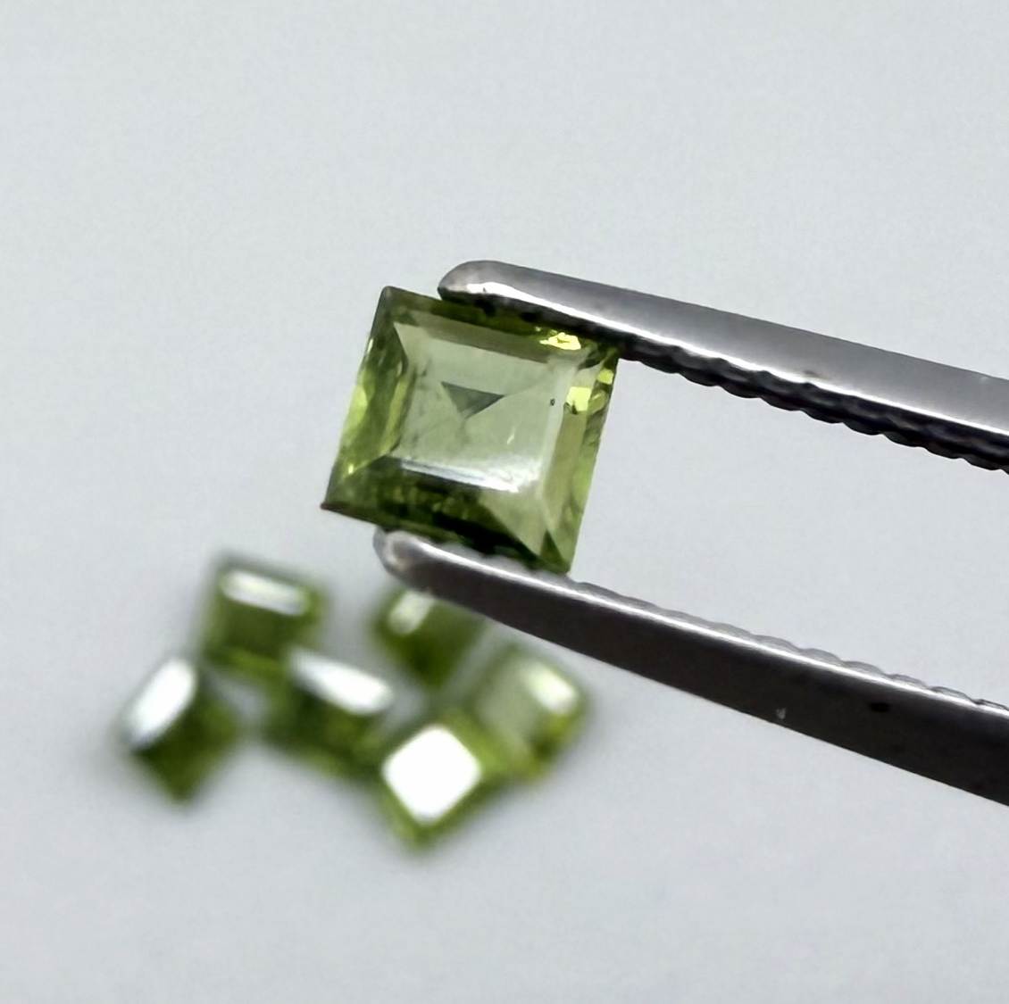 Green sapphire parcel in square cuts from Bangkaja, Thailand showing olive to yellowish-green tones with natural brilliance.