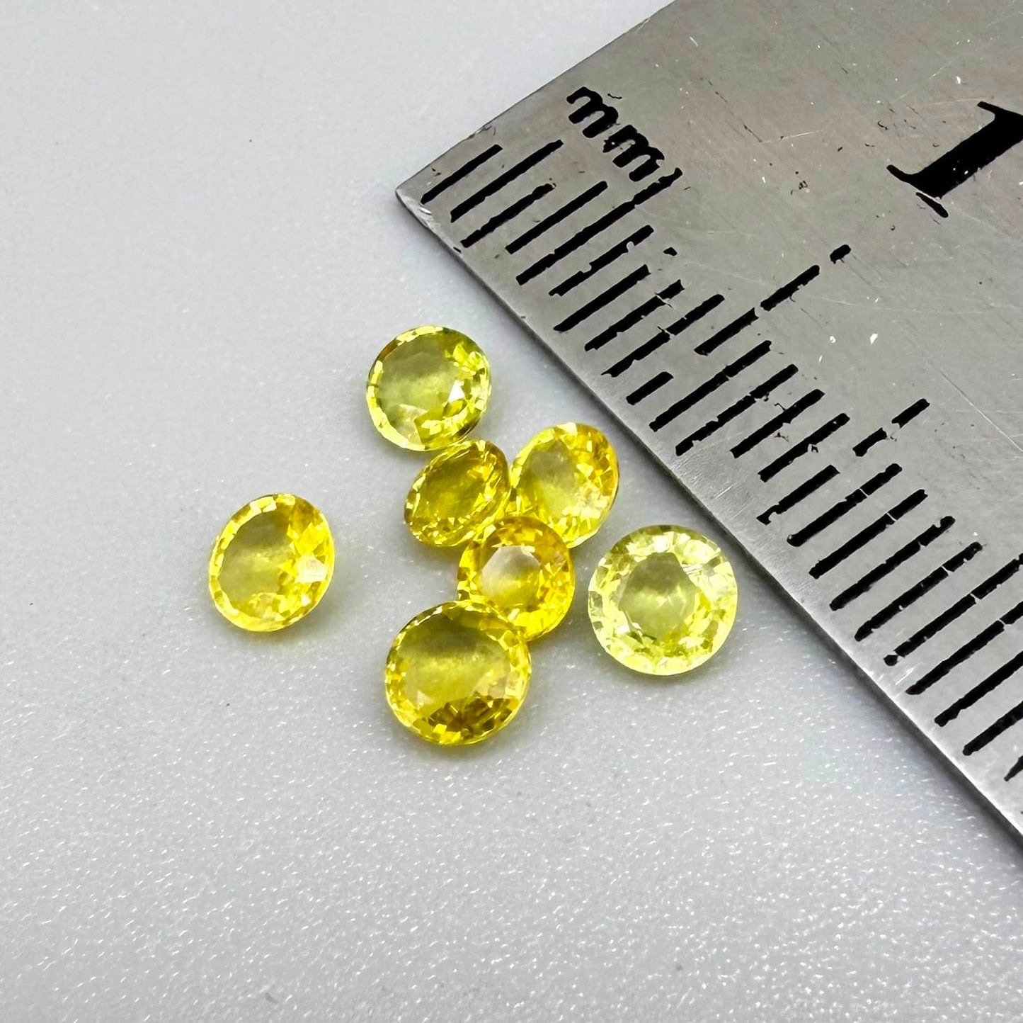 Yellow sapphire parcel in oval and round cuts from Bangkaja, Thailand showing lemon to light golden tones with bright natural brilliance.